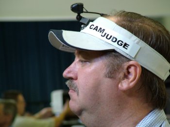 Tom Lynch our Cam Judge. Small camera sends signal wireless to TV outside hall. Exhibitors could sit outside while Tom explained how he judged birds in the line up.