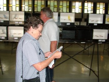 Val Nagel checking her exhibits with Gert Pieters in the background.