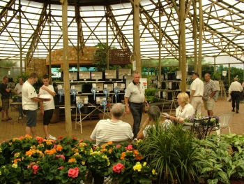 Members viewing some of the Finch exhibits while sitting relaxing surrounded by flowers and various plants