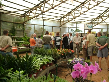 Members in the venue surrounded by flowers and various plants