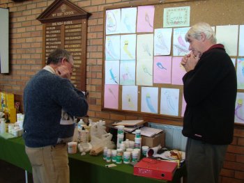 Pat (right) with table of various foods and additives. Note children drawings of budgies on the wall.