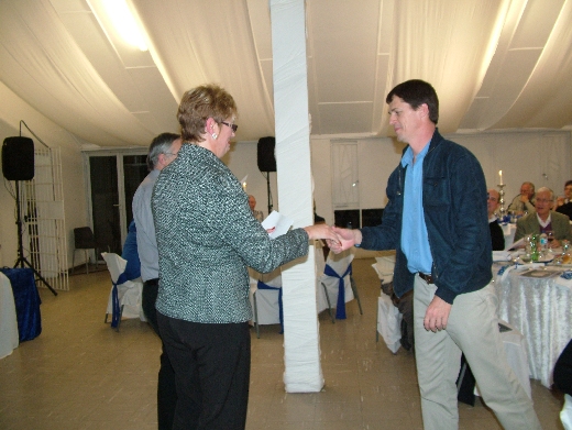 Deon Davie receives awards from Maja Swart.