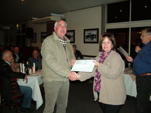 Tony Slight receives the Challenge Certificate for Best Spangle Blue and Yellow Face on Show from Elke de Witt.