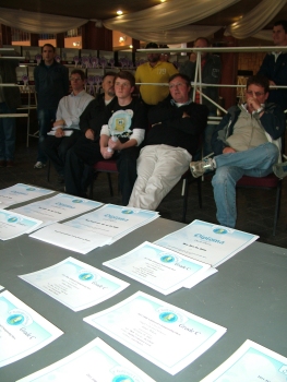Members at the prize giving with diplomas in the foreground